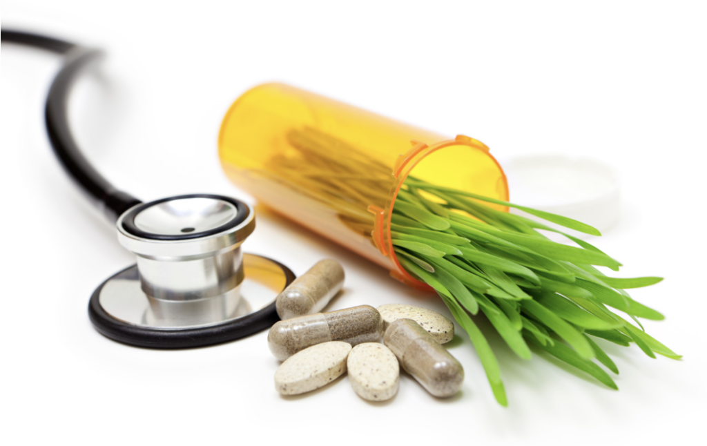 stethoscope next to pills and pill bottle with grass